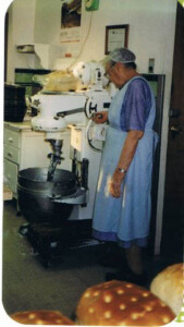 Mama in the bakery; the mixer mixes 60# of dough at a time.